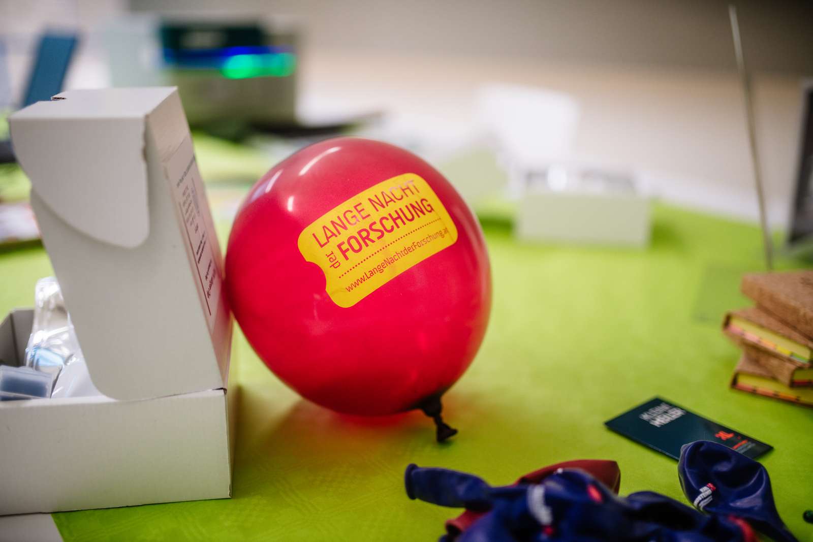 Lange Nacht der Forschung: Luftballon  mit Branding auf grünem Tisch