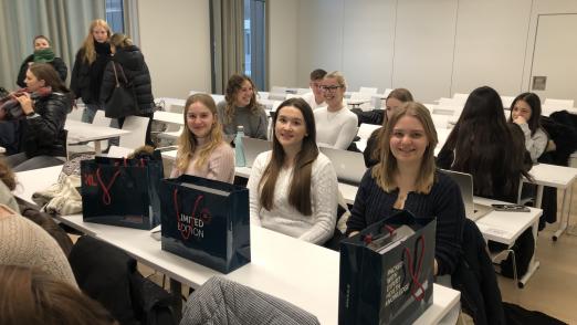 Uniluft schnuppern - Drei Schülerinnen sitzen im Vorlesungssaal und lächeln in die Kamera