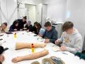 Schüler:innen versuchen sich an Nahten und Blutabnahme an Modellen im Skills Lab
